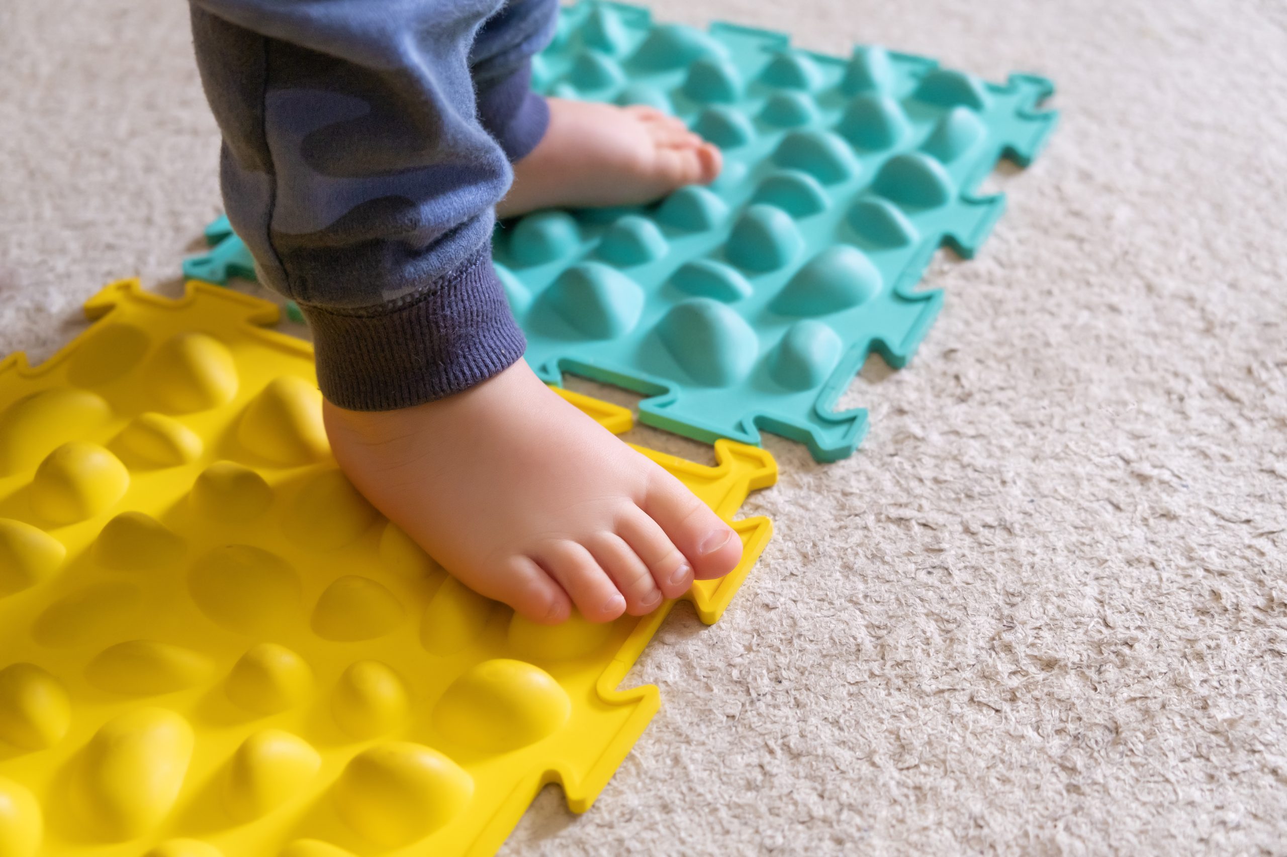 Small baby feet on the ribbed rug